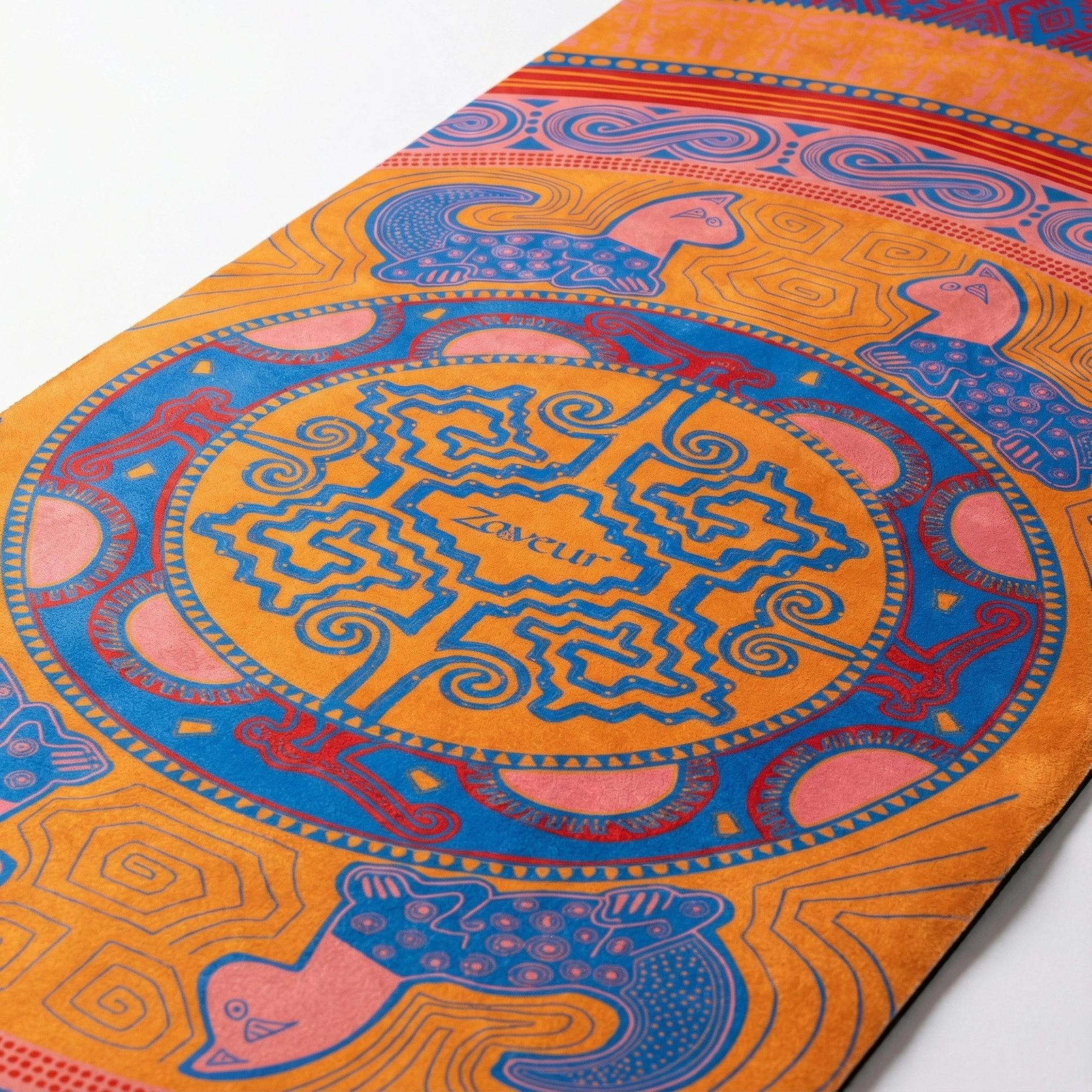 Detailed view of yoga mat center showing intricate mandala medallion with yin yang symbol, surrounded by peacock figures and decorative borders in orange and blue