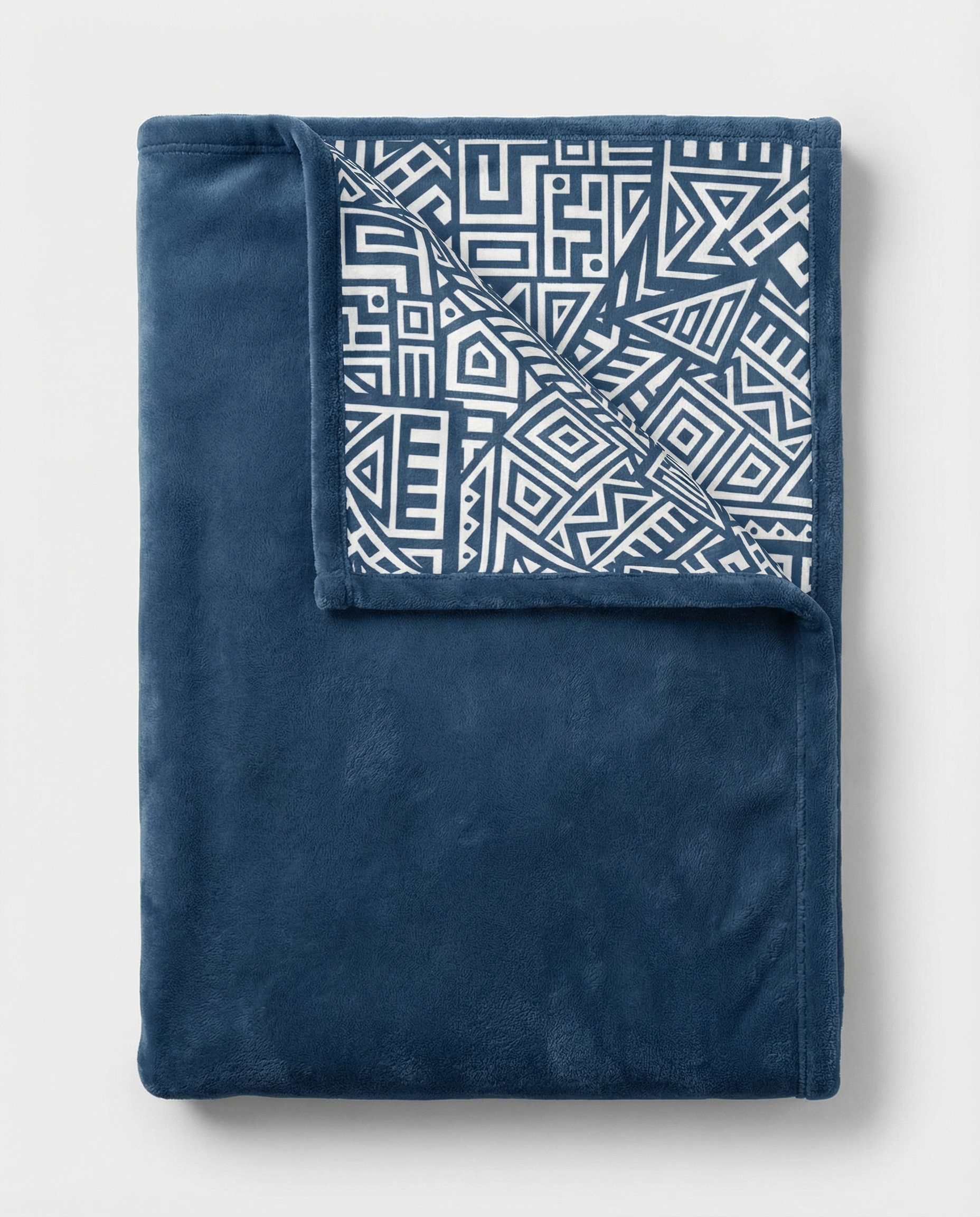 Back view of a blue fleece blanket showcasing a bold African geometric pattern in white, displayed flat on a clean background