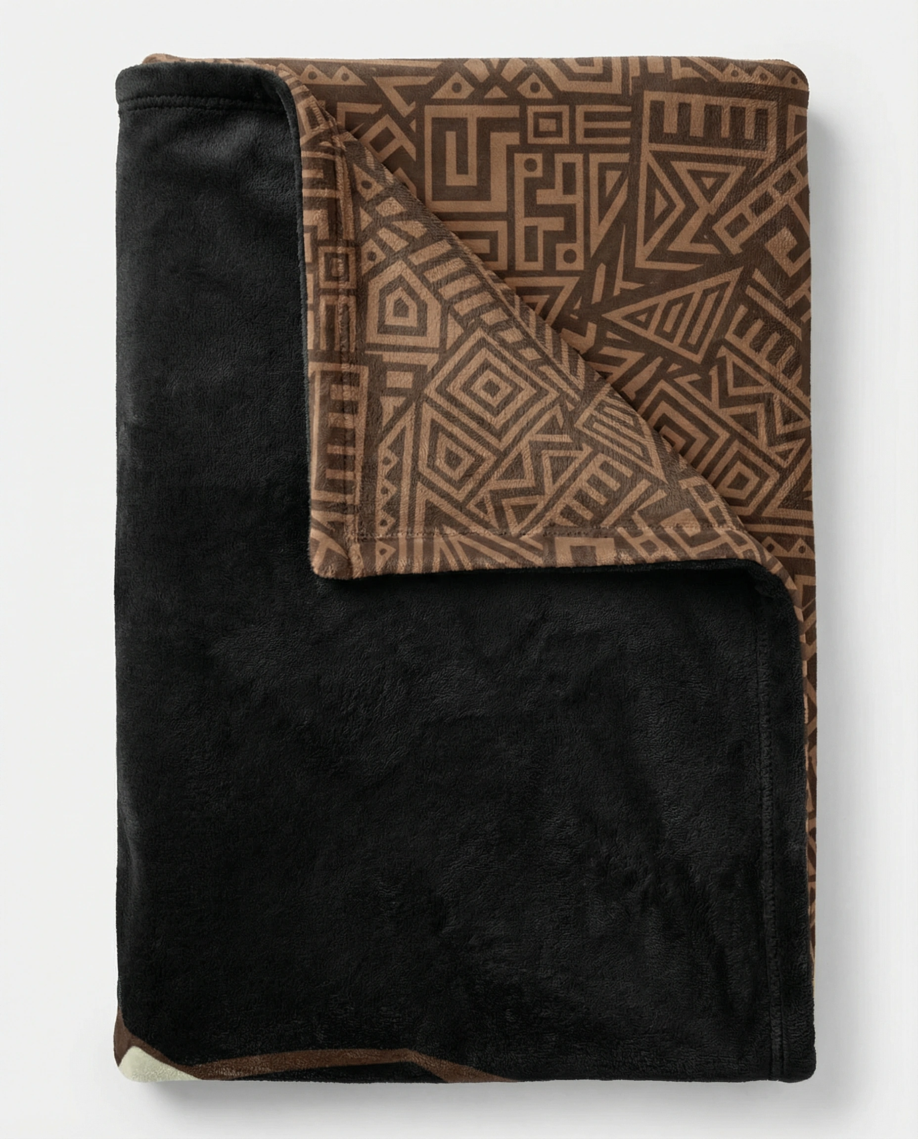 Folded reversible fleece blanket showing a soft black plush side and a brown African geometric pattern interior, emphasizing warmth, thickness, and premium comfort