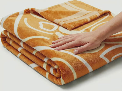 Product showcase video of a reversible African tribal dancers fleece blanket, focusing on soft texture, bold artwork, and premium quality details